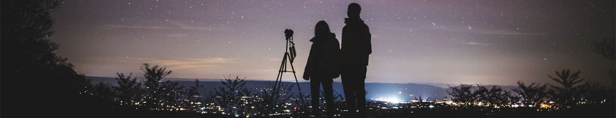 Любители астрономии на фоне звездного неба